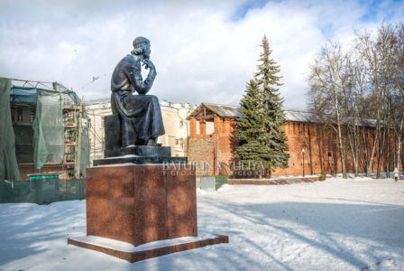 Памятник зодчему Федору Коню рядом с кирпичной стеной в Смоленске