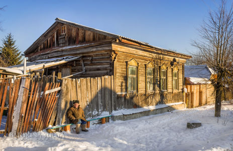 Местный житель и деревянный деревенский дом, зимняя Верея, Подмосковье